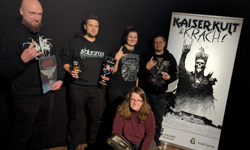 Die Vorfreude auf die neue Sonderausstellung "Kaiser, Kult & Krach – 66 Stories aus Hard Rock und Metal" ist groß: Dr. Jan Habermann, Marvin Voges und Marleen Mützlaff, alle Stadt Goslar, präsentieren zusammen mit Amelie Heger und Kai Wilhelm, beide RockHarz, erste mögliche Ausstellungsstücke (v. li.).