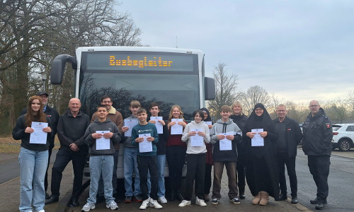 Neben den Achtklässlern stehen Knut Hirschfeld (Busfahrer), Ulf Blanke (Gesamtschuldirektor), Marc Klinkert (Jahrgangsleiter), Silke Hitschfeld (Polizei), Dirk Rodenstein (Fahrdienstleiter WVG) und Jens Oertelt (Polizei).