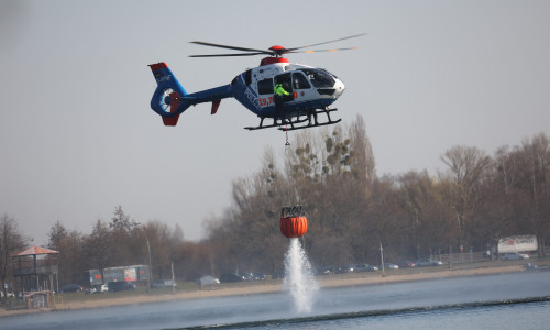 Der Hubschrauber der Polizei nimmt Wasser aus dem Salzgittersee auf.