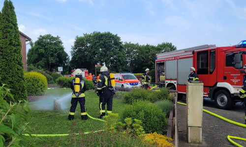 Kühlung der Gasflasche durch einen Trupp unter Atemschutz.