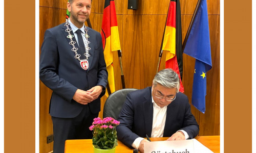 Oberbürgermeister Dennis Weilmann (links) mit seinem Gast beim Eintrag ins Gästebuch der Stadt. 