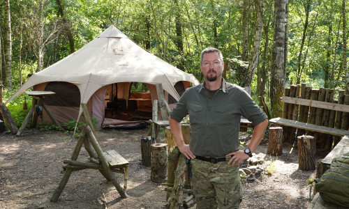Stefan Winkler vor dem Gruppenzelt in seinem Survivalcamp.