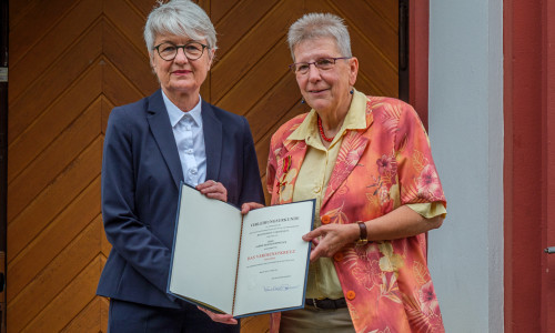 Stellvertretend für den Bundespräsidenten übernahm Landrätin Christiana Steinbrügge (l.) die Verleihung des Bundesverdienstkreuzes an Sabine Resch-Hoppstock (r.).