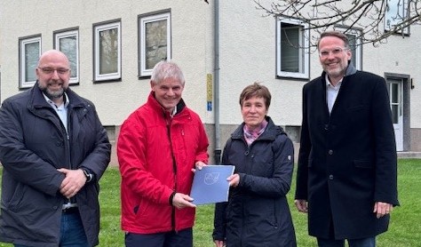 Erster Stadt Eric Neiseke, Oberbürgermeister Frank Klingebiel, Dezernatsleiterin Astrid Paus und Stadtbaurat Michael Tacke bei der Bescheidübergabe in der Ostsiedlung im Dezember 2024.