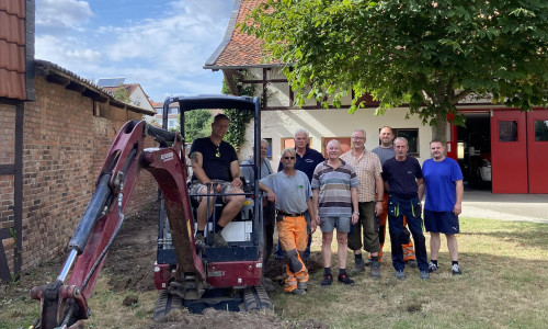 Erster Spatenstich für das Kleine Spritzenhaus: Im Bagger Ortsbrandmeister Matthias Hartlich, dann weiter von links Jens und Christian Behrens, Henning Plumeyer, Helge Michler, Frank Oesterhelweg, Simon Gloger, Bernd Isaak und Tim Helbig.