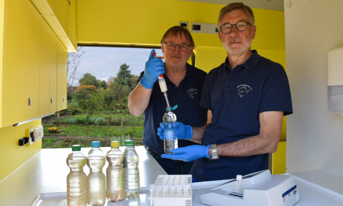 Arno Mittelmeyer und Heinz-Theo van Wickeren untersuchen eine Brunnenwasserprobe im Labormobil des VSR-Gewässerschutz e.V..
