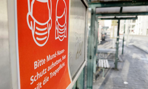 Hinweis auf Mund-Nasen-Schutz an einer Straßenbahnhaltestelle (Archiv)