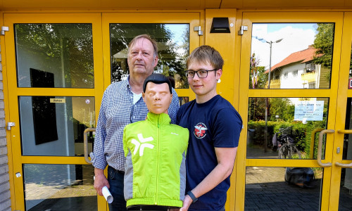 Stephan Pinkert und David Kröger präsentieren die neu erhaltene Reanimationspuppe, mit der THG-Schülerinnen und Schüler zukünftig in Wiederbelebungsmaßnahmen geschult werden können.