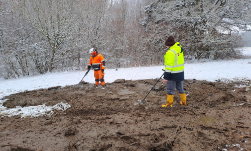Fachleute bei der Sondierung des ausgehobenen Teichschlamms auf der Wiese.