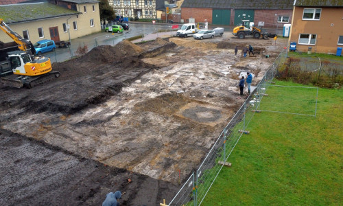  Das Baufeld im Ortskern von Ehra-Lessien mit der Verfärbung eines Holzkastenbrunnens im Vordergrund.