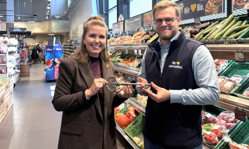 Julia Ogiermann übergibt den symbolischen Schlüssel an Rolf Kruse, den neuen Marktleiter des Edeka Centers in der Allerstraße. 