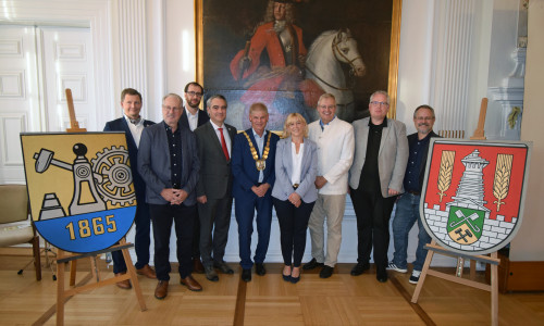 : Zwischen den Stadtwappen von Kattowitz (l.) und der Stadt Salzgitter (r.): v.l.  Maksymilian Michalek, Gunter Kostorz, Jacek Malcher, Stephan Rauhut, Oberbürgermeister Frank Klingebiel, Sarah Krieger, Heiko Schmelzle, Christoph Lücke, Arne Homann.