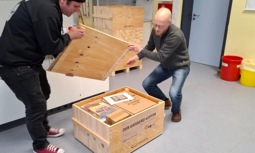 Die Lehrer Sebastian Pach (re.) und Dr. Alexander Witt öffnen einen Teil des „Koffers“, der die neue Schulgießerei enthält.