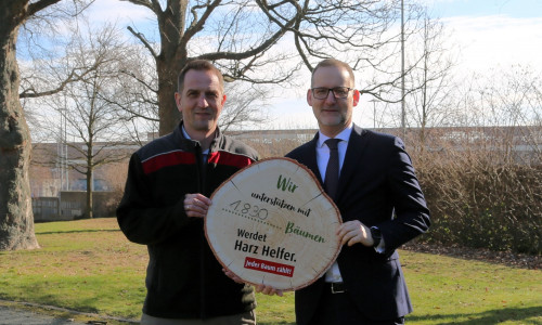Michael Vogler (Volksbank BRAWO, Foto rechts) überreicht Cord Meinecke von den Niedersächsischen Landesforsten symbolisch die 1.830 Bäume für die Aufforstung im Harz.