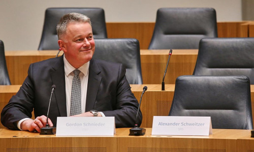 Gordon Schnieder sitzt neben dem leeren Stuhl von Alexander Schweitzer am 22.03.2026