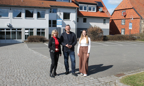 Claudia Kayser (Leiterin der Direktion Wolfsburg der Volksbank BRAWO), Andreas Busch (Bürgermeister der Gemeinde Lehre) und Lara Höthke (Mitarbeiterin im Bereich Liegenschaften bei der Volksbank BRAWO) auf dem Parkplatz der Volksbank BRAWO in Lehre (v. li.).
