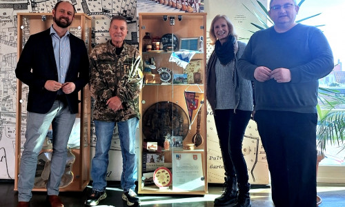 Bürgermeister Malte Schneider (li.) und die Vertreter des PVS an der Partnerschaftsvitrine im Schöninger Rathaus. Die Souvenirs erinnern an die Reisen und Besuche in friedlichen Zeiten: Vereinsvorsitzender Peter Voß, Marita Soltysiak und Jan Fricke.