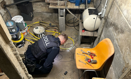 Zöllner bei der Durchsuchung eines Kellers einer Gartenhütte auf dem Grundstück der einen Beschuldigten.