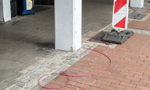 Das Glasfaser-Leerrohr kommt auf dem Gehweg einfach so aus der Erde.