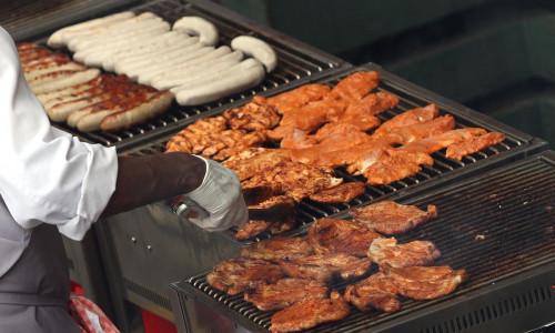 Hähnchenschnitzel und Würste auf einem Grill (Archiv)