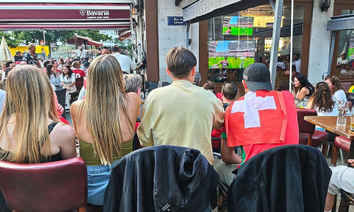 Fans und Interessierte schauen in einer Bar in Genf Fußball