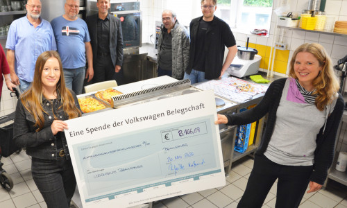 Übergabe des symbolischen Schecks an die Lebenshilfe Braunschweig - im Hintergrund der Konvektomat, der für das Geld aus der Belegschaftsspende angeschafft werden konnte.