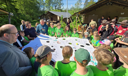 Die Junior-Ranger spielten mit Bundesumweltminister Carsten Schneider (2.v.li. hinten) und dem niedersächsischen Umweltminister Christian Meyer (links vorne) das Spiel "Der Weg des Luchses".