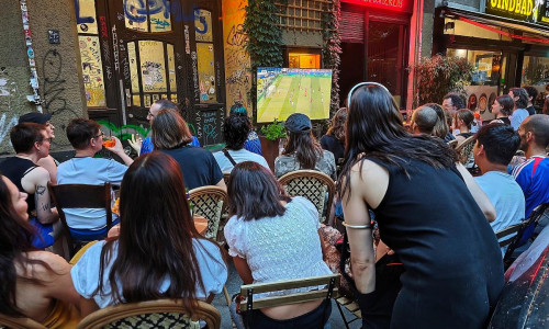 Interessierte schauen auf der Straße Fußball am 26.06.2026