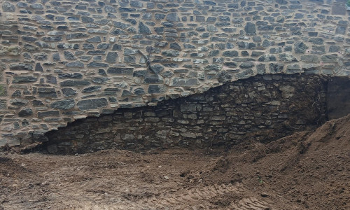 Im inneren Bereich des Pfalzgartens wird derzeit ein Teil der Böschung entlang der Stadtmauer abgetragen, um das mittelalterliche Durchgangsportal dauerhaft freizulegen.