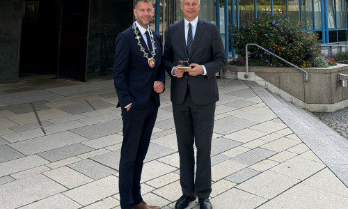 Bundesverkehrsminister Steffen Bilger (re.) mit Oberbürgermeister Dennis Weilmann vor dem Wolfsburger Rathaus.