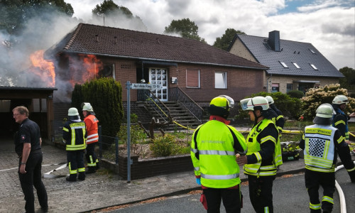 Küche im Vollbrand beim Eintreffen erster Kräfte: Aus beiden Fenstern (links vorn und Seite) schlagen massiv Flammen, Rauch steigt bereits aus dem Dachstuhl.