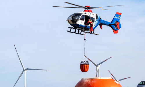 asseraufnahme im Flug: Der Hubschrauber taucht den „Bambi Bucket“ in den mit Löschwasser gefüllten Flex-Tank ein und kann ihn so ohne Befüllungsmannschaft am Boden aufnehmen.