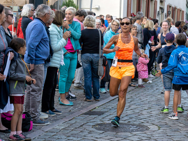 Anke Meinberg läuft in Heitersheim durch die stimmungsvolle Zuschauergasse ins Ziel. Foto: Friedrich-Wilhelm Schneider