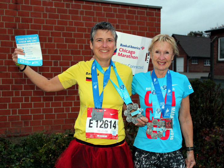 Vor der Denkter Turnhalle zeigen Bettina Börgmann (links) und Cordula Schwarz stolz ihre Medaillen und andere Andenken vom letzten Marathon. Foto:Bernd-Uwe Meyer