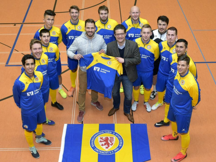 Freuen sich über eine komplett neue Trainingsausstattung: Die Futsal-Mannschaft von Eintracht Braunschweig. Carsten Ueberschär (Mitte rechts), Leiter der Direktion Braunschweig der Volksbank BraWo, übergab die Aufwärmpullover- und Shirts an Claus Ludwig, Leiter Marketing / Sponsoring. Foto: Volksbank BraWo