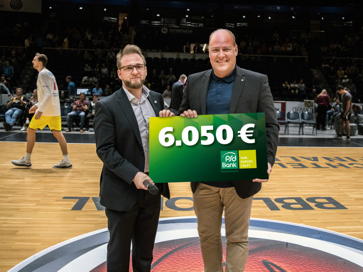 Sebastian Schmidt (li., Geschäftsführer Basketball Löwen) und Carsten Graf (Vorstandssprecher der PSD Bank Braunschweig eG) bei der symbolischen Scheckübergabe. Foto: PSD Bank/privat