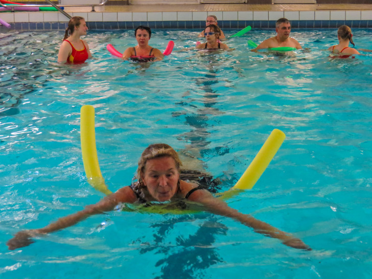 Mit einer Schwimmhilfe lernen die Erwachsenen die sorgfältigen Schwimmbewegungen. Fotos: DLRG