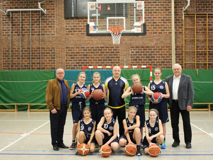 Die U-13 Mädchenmannschaft sowie der Trainer Thorsten Weinhold (Mitte) freuen sich über die gespendeten Basketbälle des Fördervereins. Hier vertreten durch den stellvertretenden Vorsitzenden Andreas Meißler (links) und dem Vorsitzenden Klaus Hantelmann (rechts). Foto/Video: Max Förster