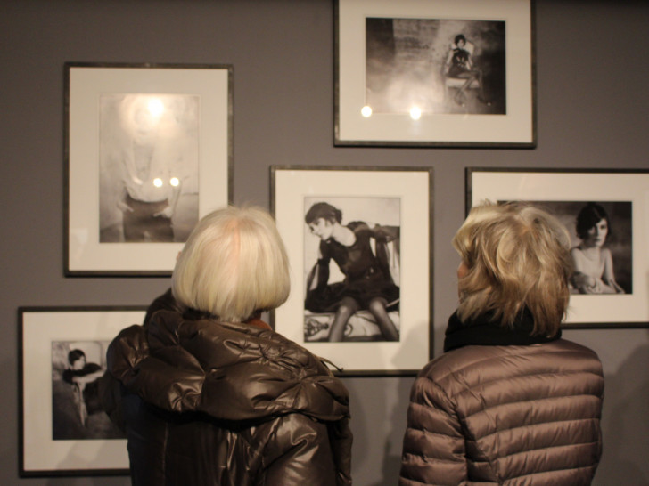 Besucher sehen sich die Fotos bei der Ausstellungseröffnung von ganz nah an. Foto: Frederick Becker
