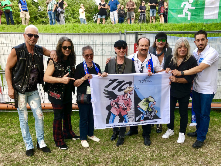 Die Scorpions und der Weiße Ring fordern mit der GZK Fahne zum „Hinsehen,Handeln und Helfen auf! Foto: Weißer Ring, Sabrina van Hüllen
