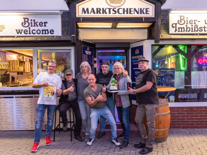 Vor der Marktschenke: Betreiber Hansel, die Musiker Mark Beerell, Chaos Company, Musikschule Vielsaitig und Manfred Kramer mit seinem kleinen grünen Drachen Tabaluga. Foto: Andreas Behrens
