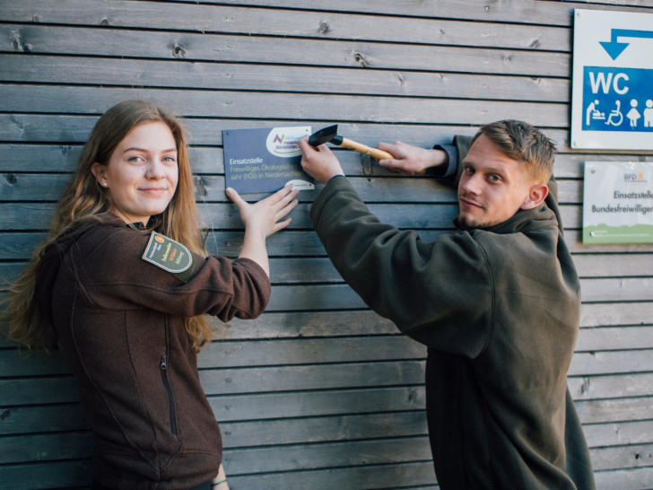 Sophie Schreiber und Jakob Husar bringen ein Schild an ihrer Einsatzstelle an. Foto: Nationalpark Harz