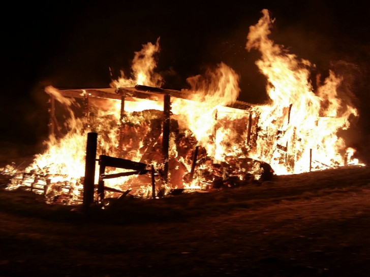 Der brennende Holzunterstand am Sportplatz, in dem Eichenholz und Heuballen lagerten. Foto: FF Sickte