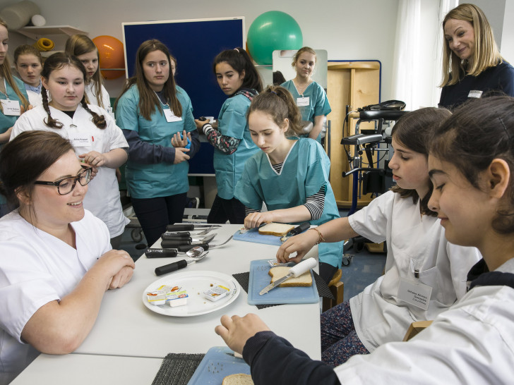 Ergotherapeutin Mona Bachmann (links) erklärt, wie Schlaganfall-Patienten lernen, ein Brot mit nur einer Hand zu schmieren. Klinikum. Fotos: Braunschweig/Peter Sierigk
