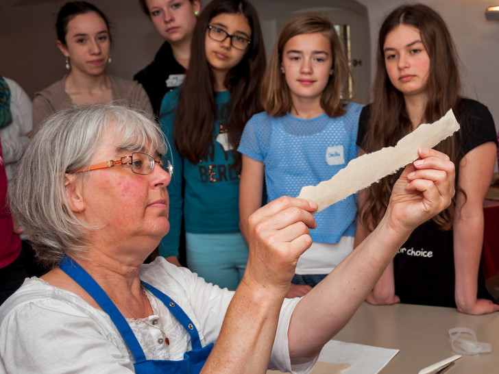 Viola Meradi führt Schülerinnen des Ratsgymnasiums in die Papierrestauration ein. Foto: HvFM/Peter Riewaldt