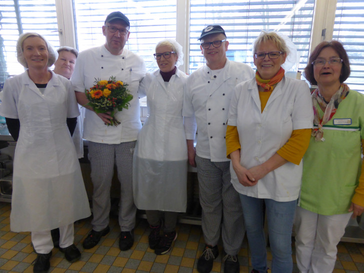 Der „20-jährige-Dienstjubilar“ Frank Hahne mit Blumenpräsent im Kreise seiner Kolleg*innen in der SchloßkücheFoto: Sabine Resch-Hoppstock