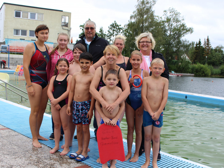 Von links: Die Schwimmtrainerinnen Anne Boczaga und Alicia Eßer, der WSV-Vorsitzende Rainer Porath, Schwimmmeisterin Pia-Maren Jaschiniak und Anja Kröger, 1. Vorsitzende des Wunschbaum e.V. sowie Sonja Fritz vom Jugendamt (vorne) freuen sich mit den Kindern. Foto: Max Förster