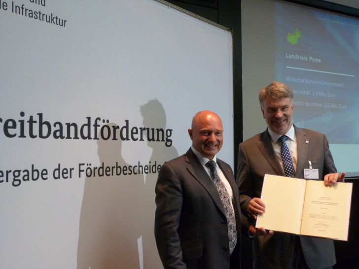 Kreisrat Henning Heiß nahm den Förderbescheid aus den Händen von Staatssekretär Rainer Bomba entgegen. Foto: Büro Heil