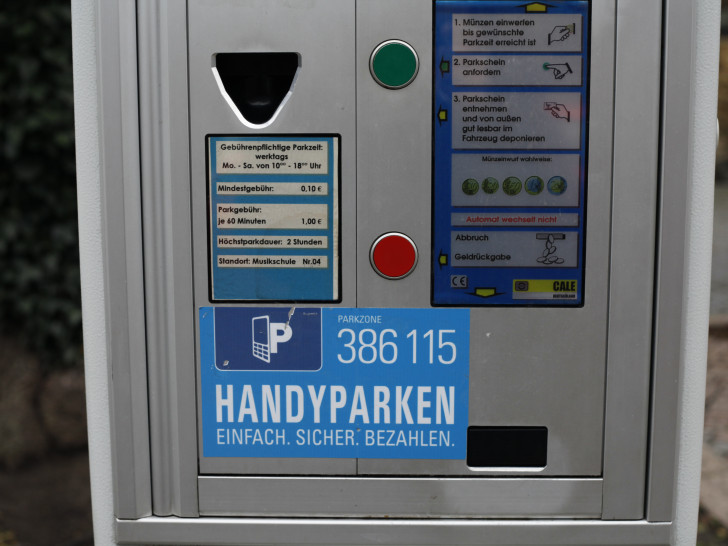 Aufkleber auf Parkautomaten weisen auf die Möglichkeit hin, auch per Handy Parkzeit zu buchen. Foto: Alec Pein