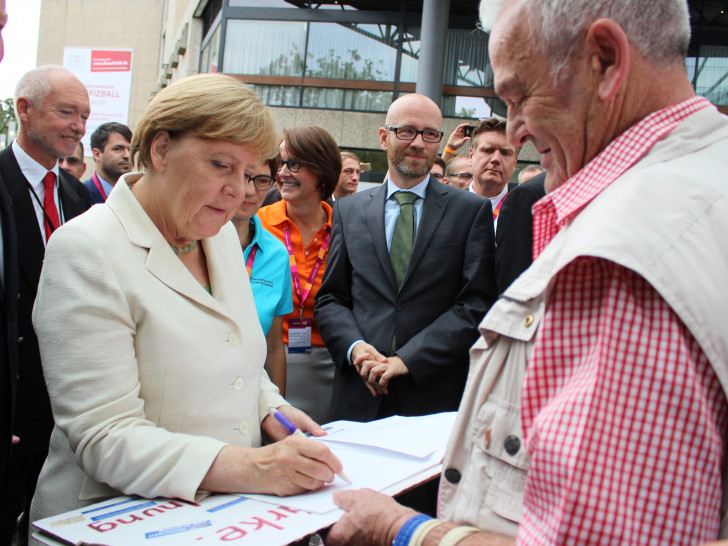 Angela Merkel gab dem standhaften Wolfgang Wolters ein Autogramm und tauschte sich kurz mit ihm aus. Foto: Nick Wenkel